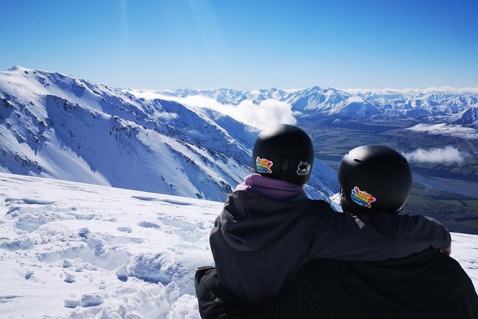 Two people on top of a ski slope
