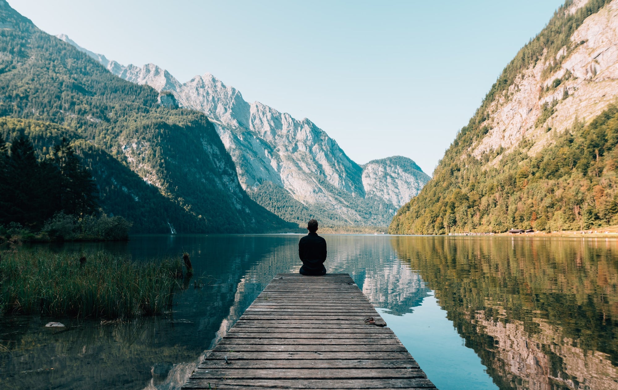 Person looking over a lake with mountains in the background